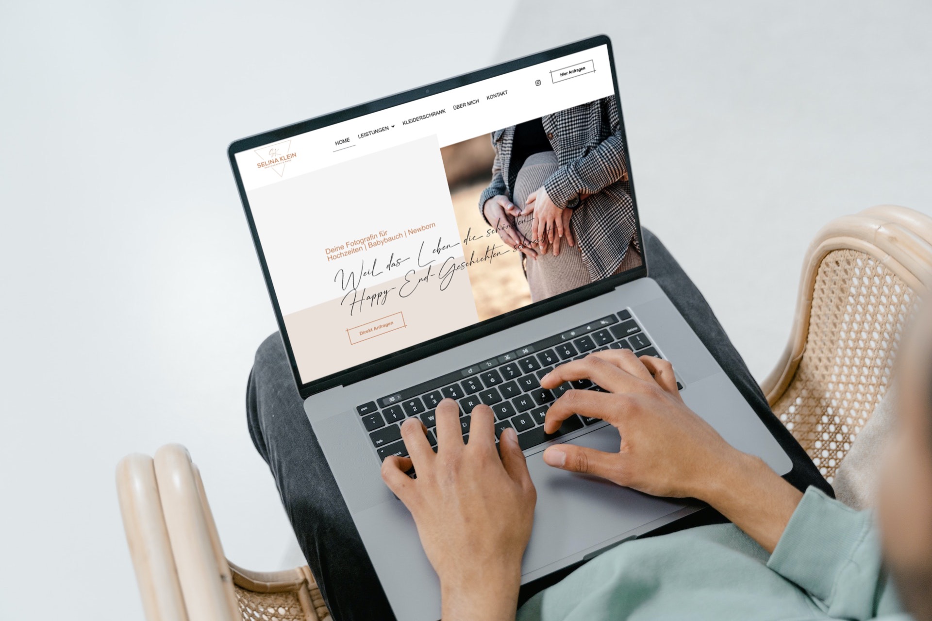 Eine Person sitzt auf einem Stuhl und verwendet einen Laptop, der ein mit WordPress erstelltes Webdesign präsentiert. Das elegante Bannerbild der Site mit einem sich an den Händen haltenden Paar ergänzt die kursive Schriftart. Die Inneneinrichtung hebt das detaillierte Design und das SEO-freundliche Layout auf dem Bildschirm hervor.